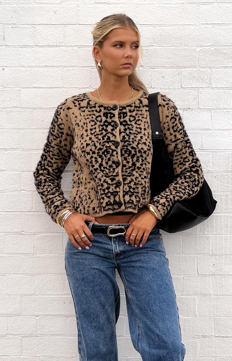 Front view of a cropped beige and black leopard print cardigan with a fuzzy knit texture and black button front