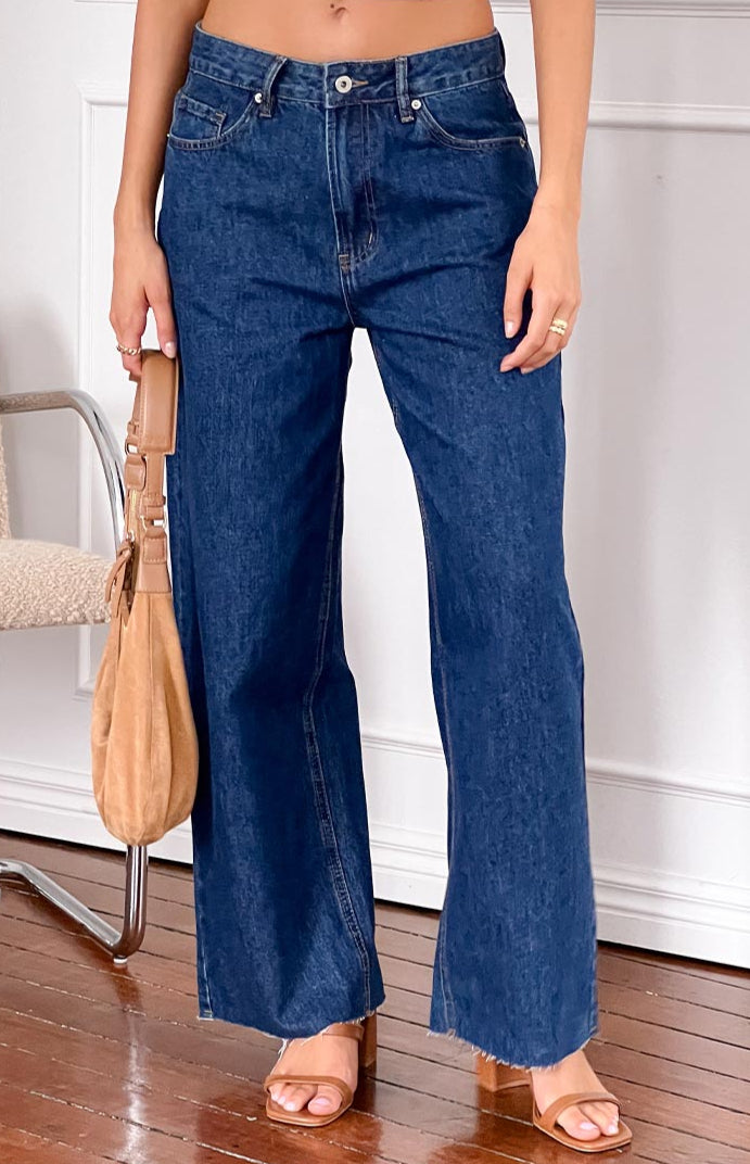 girl wearing dark wash low rise jeans with raw hem details