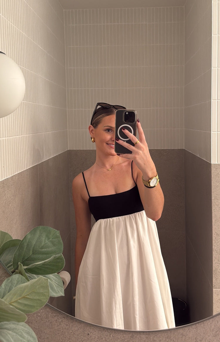 Black square neck bodice with thin spaghetti straps and a gathered white maxi skirt