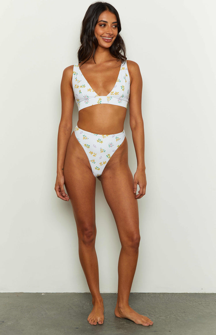 Deep V-neck white bikini top with wide shoulder straps and a supportive underbust band, yellow floral print
