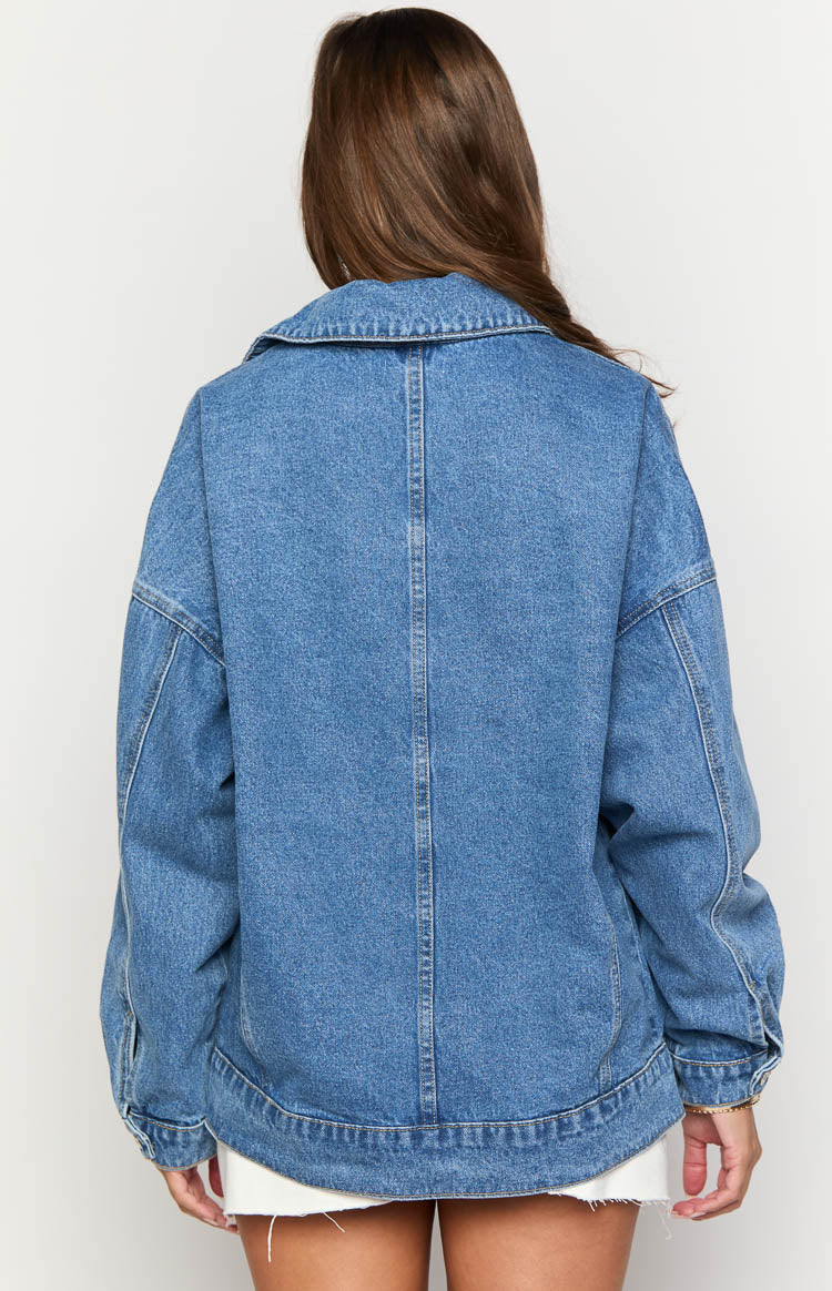 Rear view of an oversized mid wash denim bomber jacket with a wide collar and vertical back seam