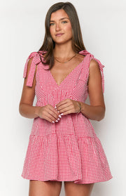 Front view of a red gingham mini dress featuring a V-neckline, tie-shoulder straps, and a gathered bodice