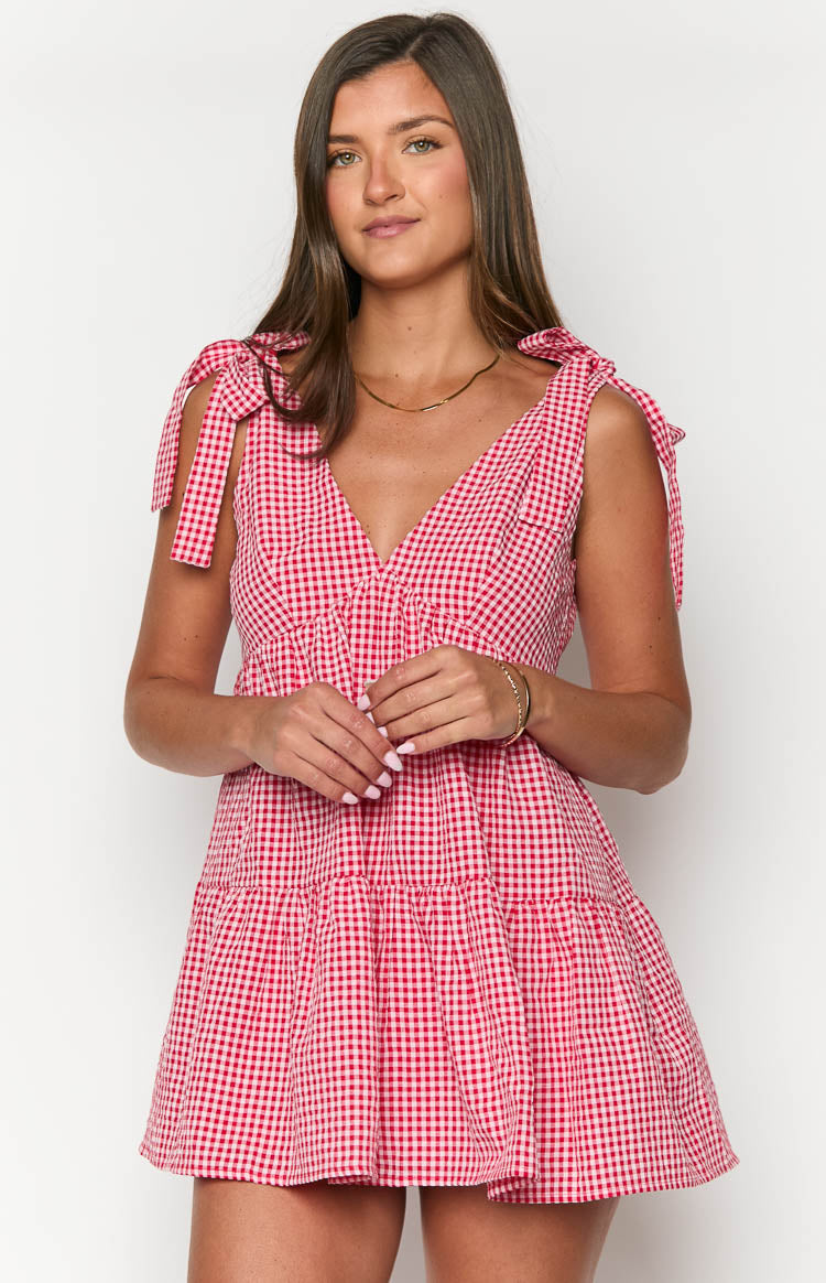 Front view of a red gingham mini dress featuring a V-neckline, tie-shoulder straps, and a gathered bodice