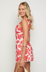 Side view of a red anemone floral print mini dress showing the ruched bust and tie-back shoulder straps