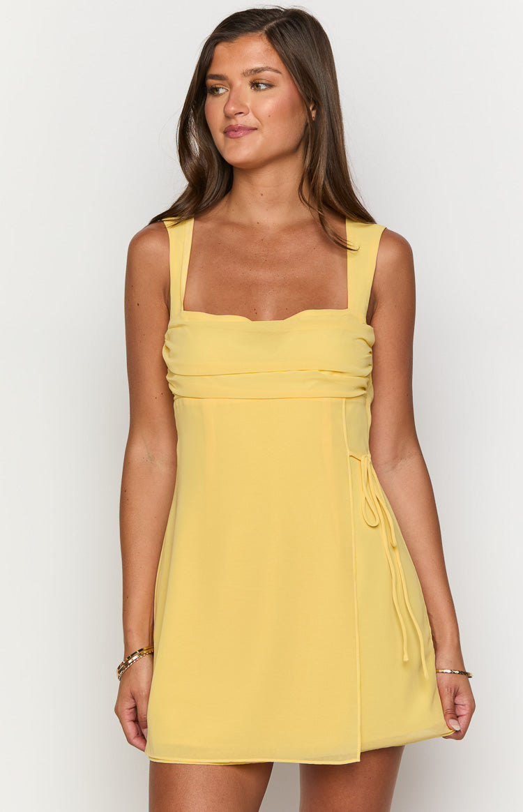 Yellow chiffon mini dress with a square neckline, ruched bodice, and side tie wrap skirt