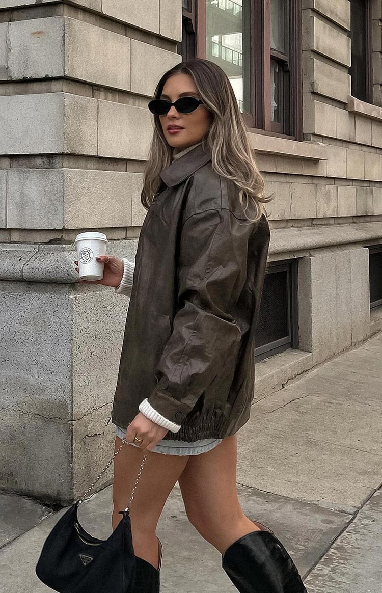 Side view of an oversized vintage brown PU bomber jacket with a wide collar and elasticated hem