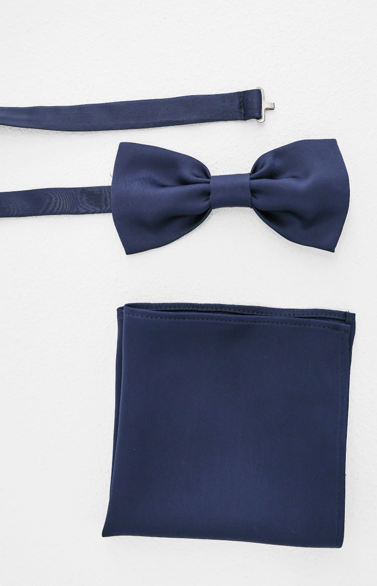 Flat lay of a navy pre-tied bow tie with an adjustable strap and a folded navy pocket square