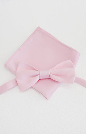 Close-up flat lay of a soft pink bow tie with a matching neatly folded pocket square