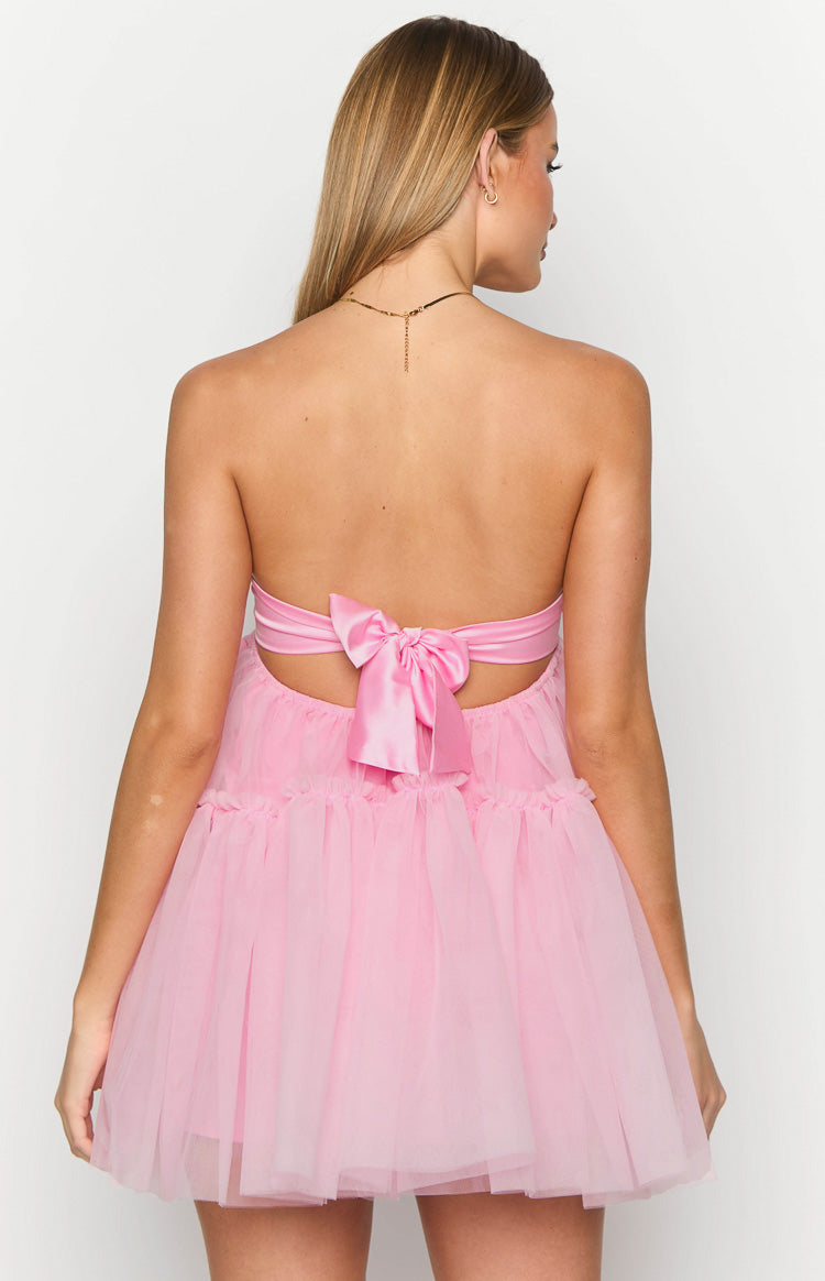 Rear view of a pink strapless mini dress with a satin tie-back bow and tiered tulle skirt