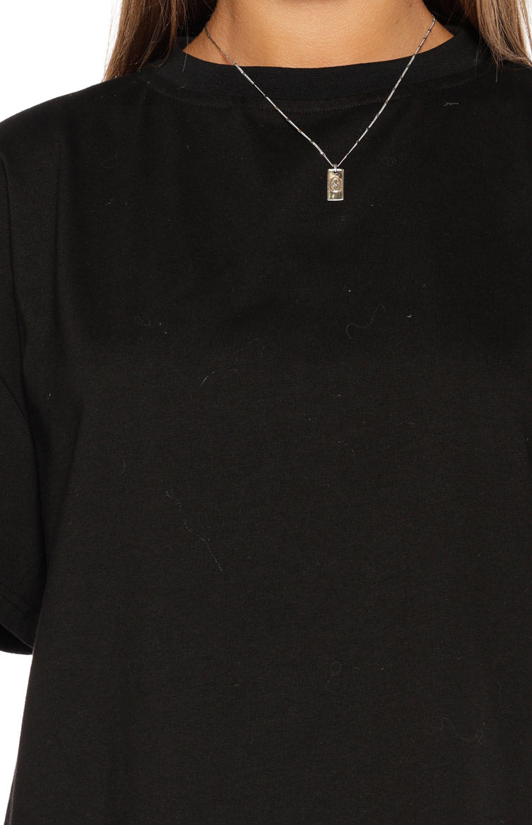 Close-up of the black crew neck tee showing the soft jersey knit fabric