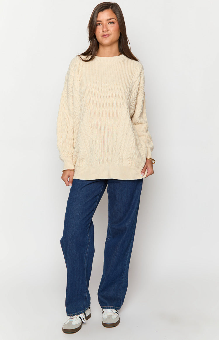 Cream oversized cable knit sweater with a relaxed fit and ribbed hem