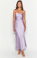 top angle of a blonde girl wearing a purple strapless satin formal gown with gold necklaces and a silver diamante handbag