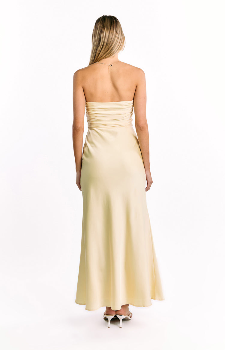 Rear view of a yellow strapless maxi dress with a ruched back bodice and flowy skirt