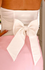 Close-up of the structured white fabric bow tied at the back of the strapless top