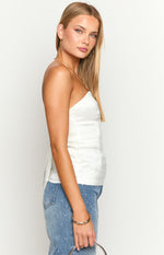 Side view of a white strapless fitted top with a textured fabric and cropped length