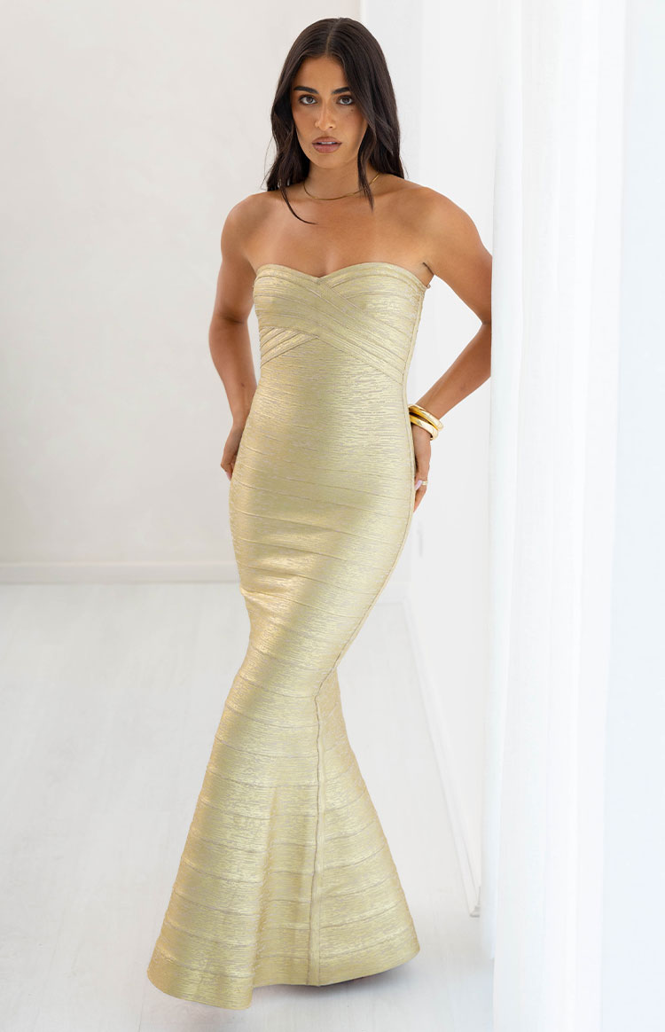 Full length view of the gold strapless bandage maxi dress with a sweetheart neckline and a flared trumpet skirt