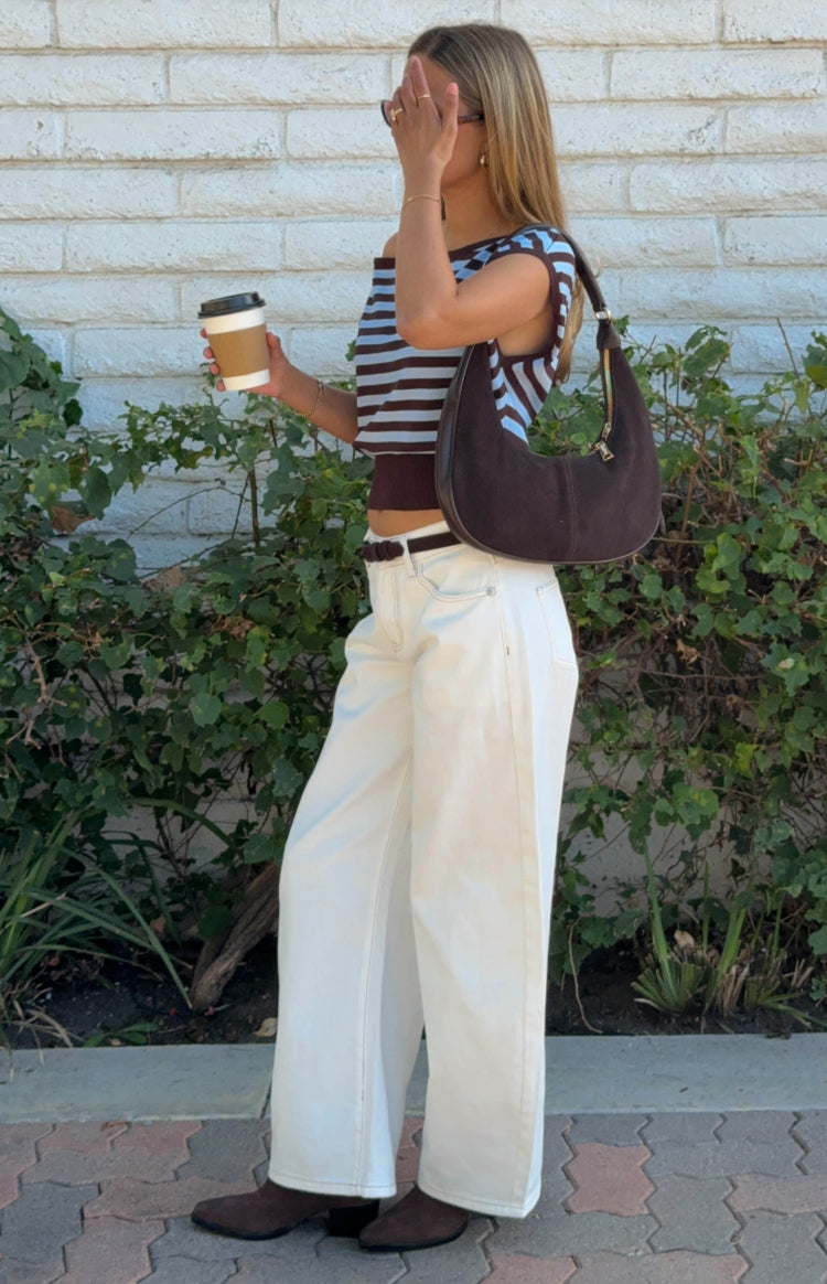 Side view of a brown and light blue stripe off shoulder knit top with a cropped hem
