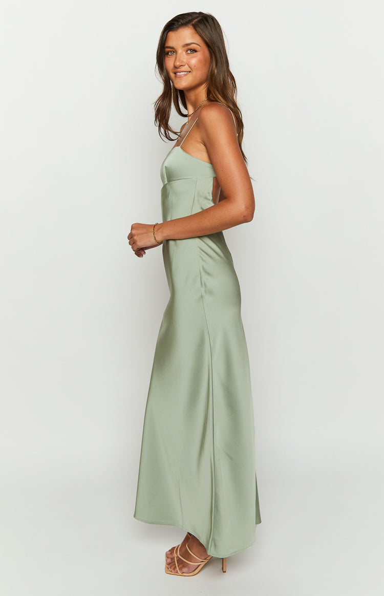 Side view of a sage satin maxi dress showing the thin spaghetti straps, side cut-out, and flowy skirt