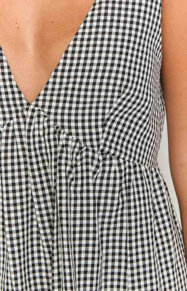 Close-up of the black gingham V-neckline and ruched empire waist of the mini dress