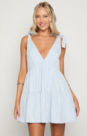 Pastel blue mini dress with tie-up sleeves and floral yellow pattern, paired with cowboy boots
