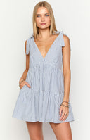 Model wearing a navy blue and white stripe flowy mini dress with adjustable tie shoulders paired with gold jewellery
