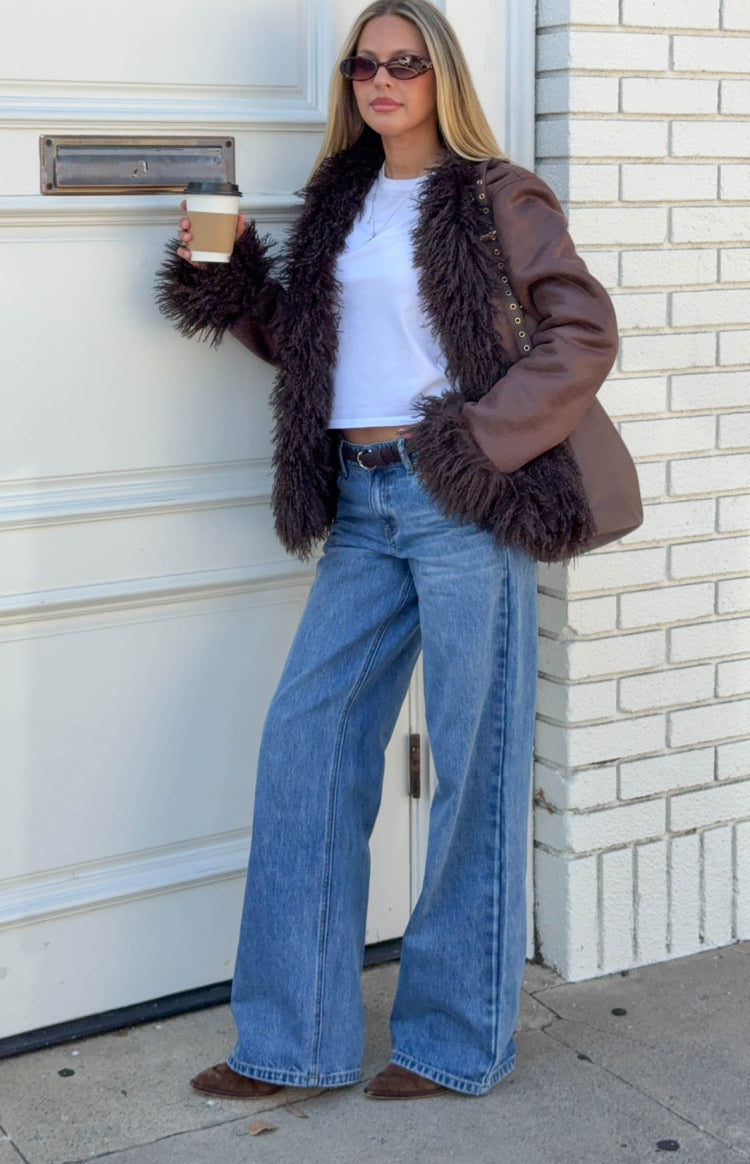 Brown faux leather jacket with shaggy dark brown fur trim on collar, cuffs, and front, featuring gold stud details