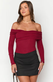 Front view of a red ribbed knit off-shoulder bodysuit with long sleeves and a draped neckline