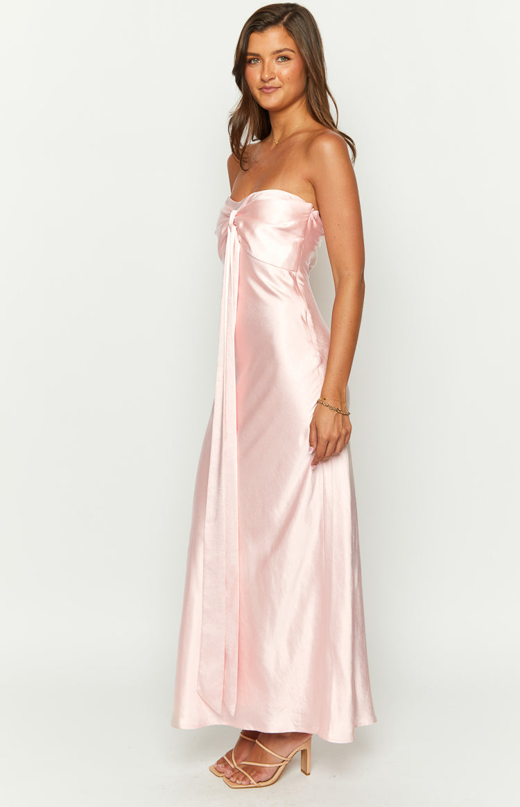 Side view of a pink satin strapless maxi dress with a front tie detail and flowy skirt