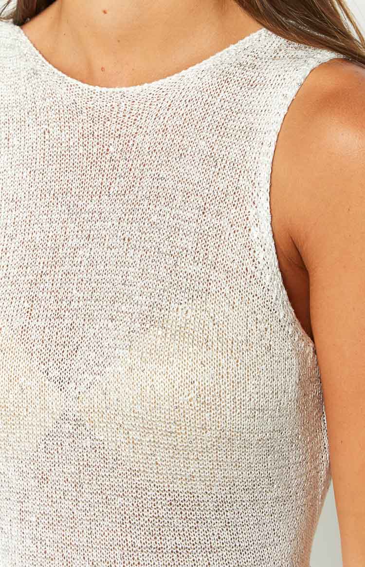 Close-up of the white sequin knit fabric showing the round neckline and sleeveless armhole