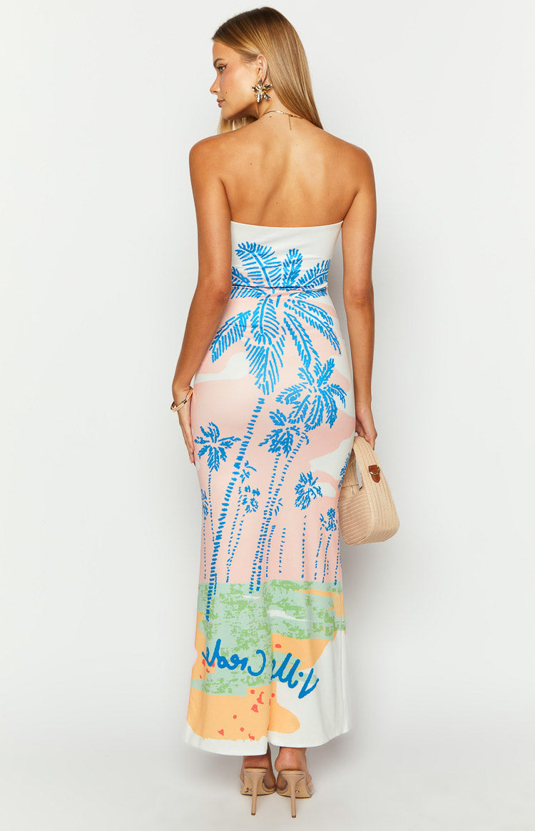Rear view of a strapless bodycon maxi dress with a vibrant blue palm print on a pink, green, orange, and white background