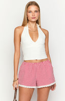 model wearing red gingham shorts with a broderie trim paired with a matching halter neck top