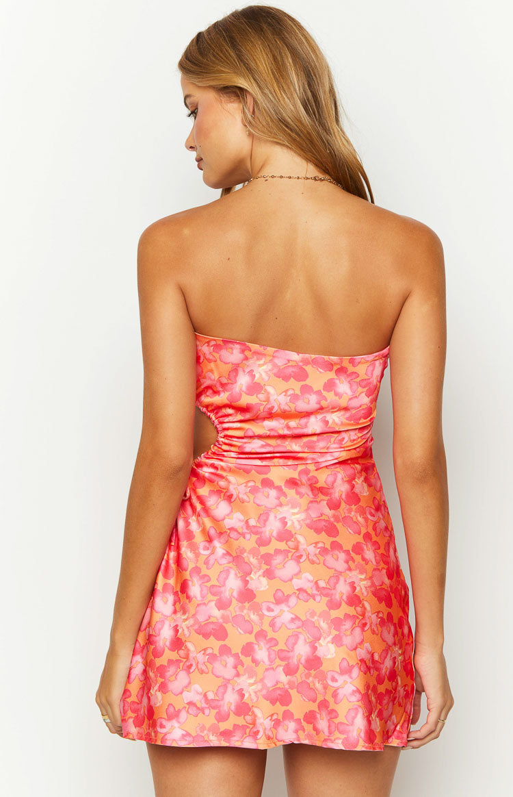 Rear view of the orange floral print mini dress with a ruched cutout on the side