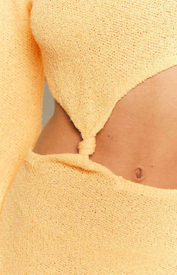 Yellow knit maxi dress with a close-up of the side cutout and knotted fabric detail