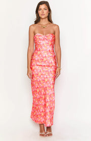 Front view of a pink and orange floral strapless maxi dress with a twisted bust and fitted silhouette