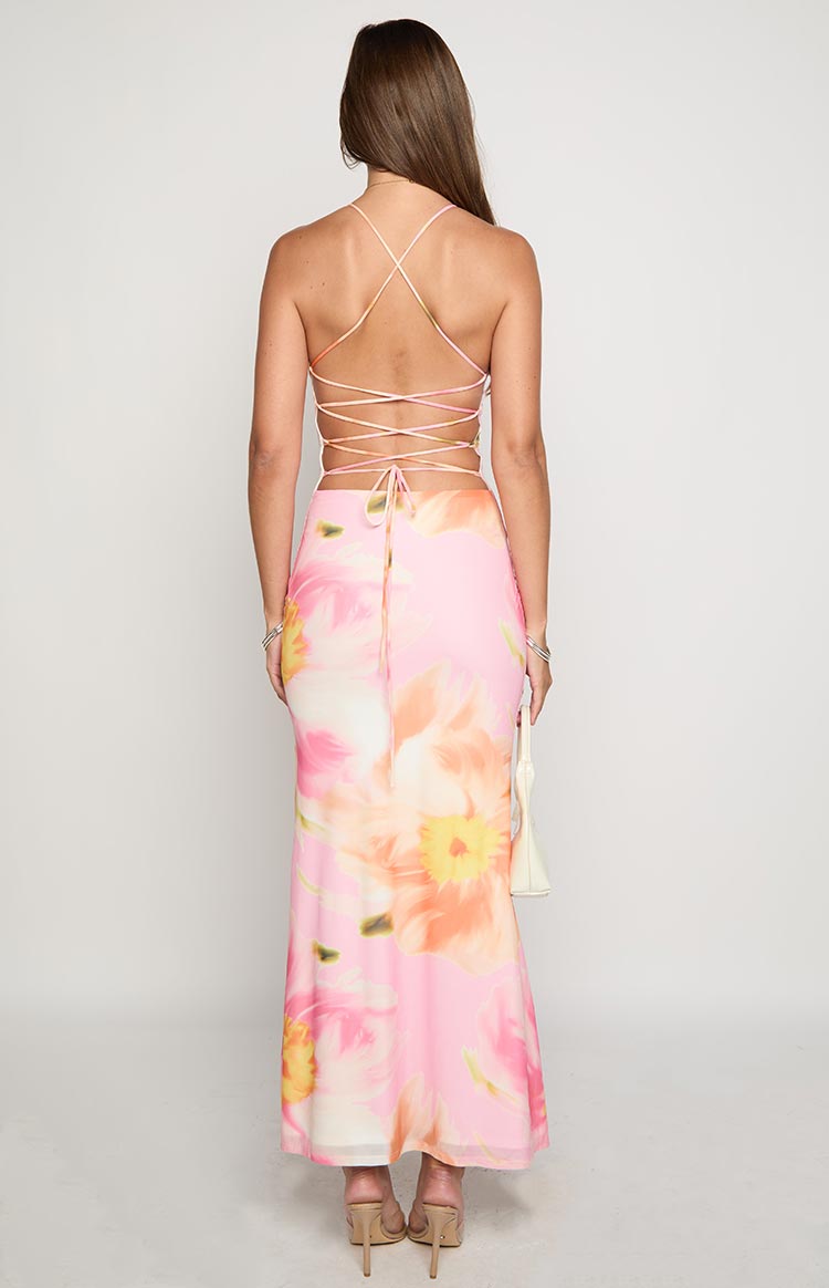 Rear view of the pink floral maxi dress showing criss-cross back straps and a tie closure at the lower back