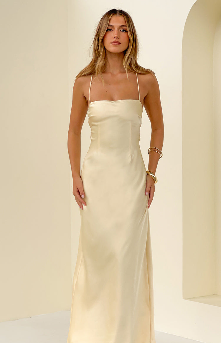 Full front view of a light yellow satin maxi dress featuring a straight neckline and delicate spaghetti straps