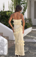 Rear view of a yellow satin maxi dress with thin spaghetti straps and ruffles across the bodice and down the skirt