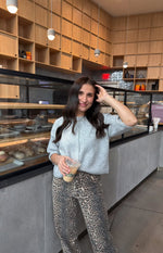 Front view of a light grey knit cropped cardigan with a round neckline, short sleeves, and button-front