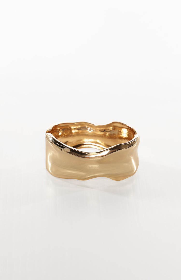 Top view of a gold wavy bangle, highlighting the irregular molten-like texture and clasp opening