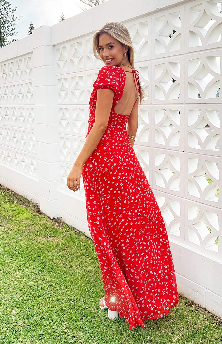 Rear view of a red floral maxi dress showing the low scoop back with tie details and short puff sleeves