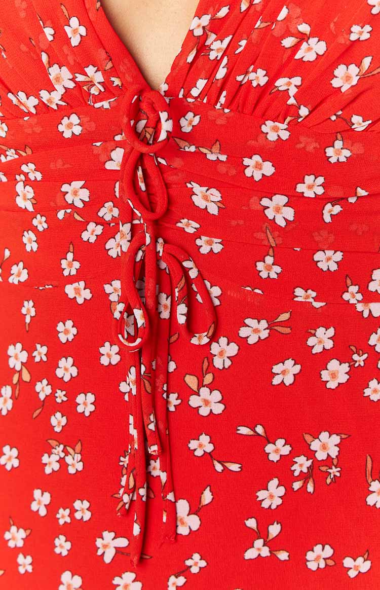 Close-up of the ruched bust with a central drawstring tie on the red floral maxi dress