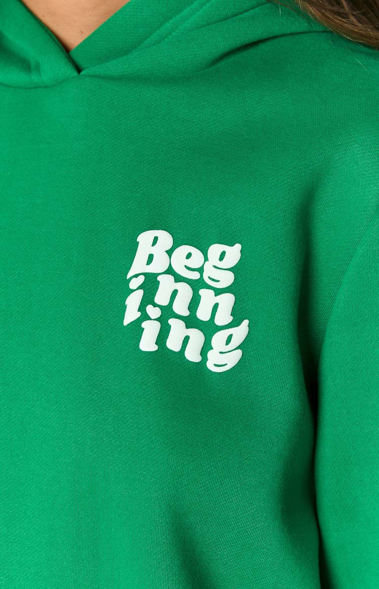 Close-up of the white Beginning graphic print on the front of a green hoodie