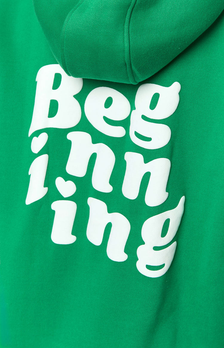 Close-up of the white raised "Beginning" text with heart details on the green hoodie fabric