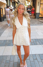 White collared mini dress with a deep V-neck, scalloped lace trim collar, fitted ruched bodice, and full button front