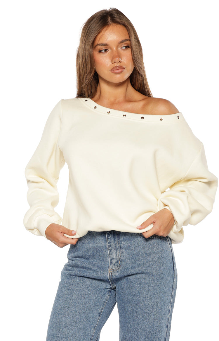 Cream relaxed fit sweater with an asymmetric eyelet neckline and voluminous long sleeves