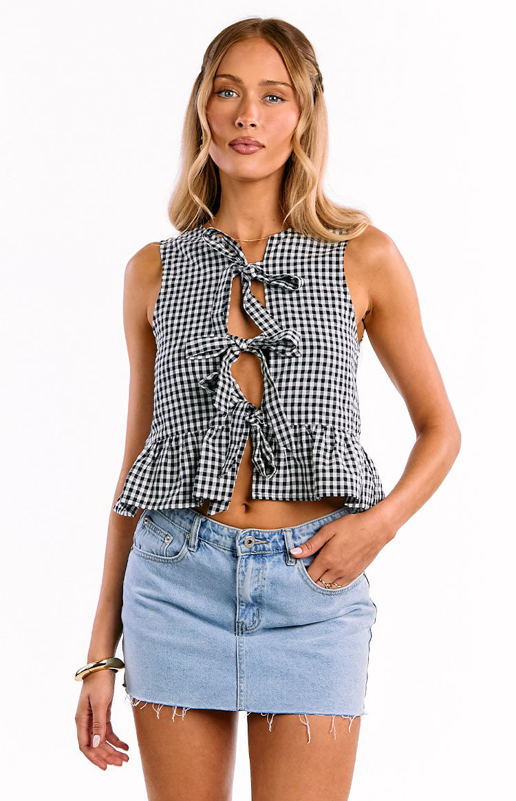Black and white gingham sleeveless crop top with multiple front ties and a ruffled peplum hem