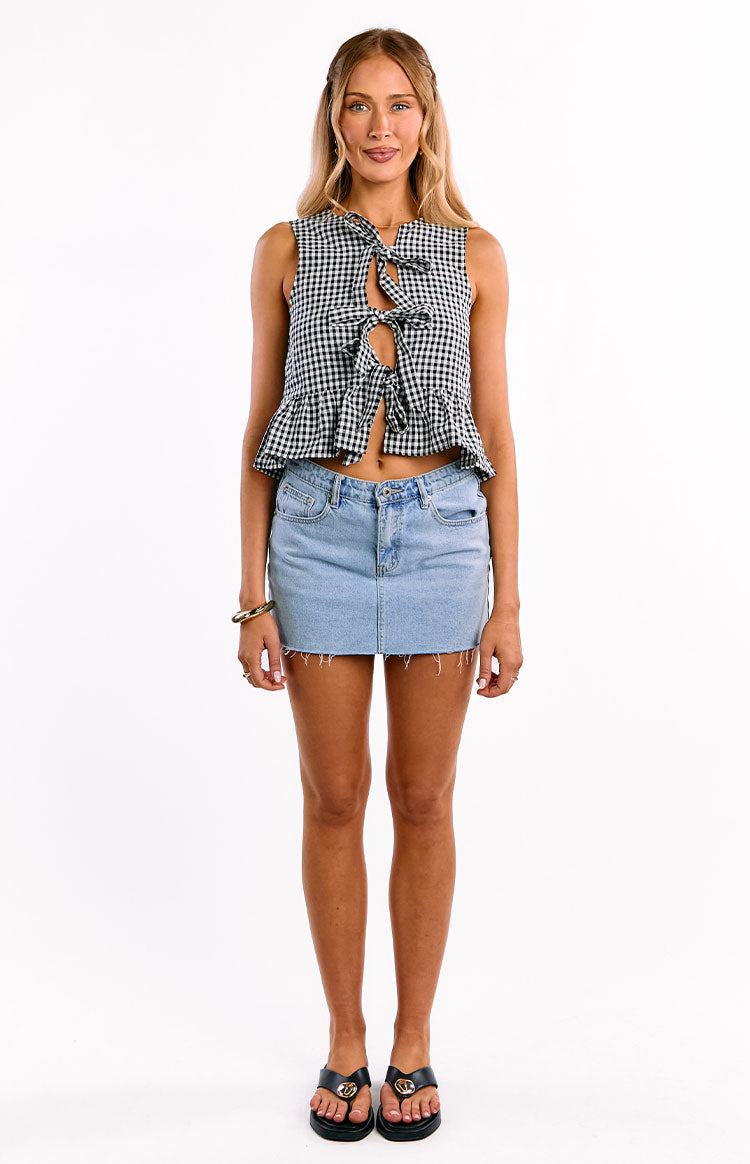 Front view of a black gingham sleeveless top with multiple tie-front closures and a ruffled peplum hem