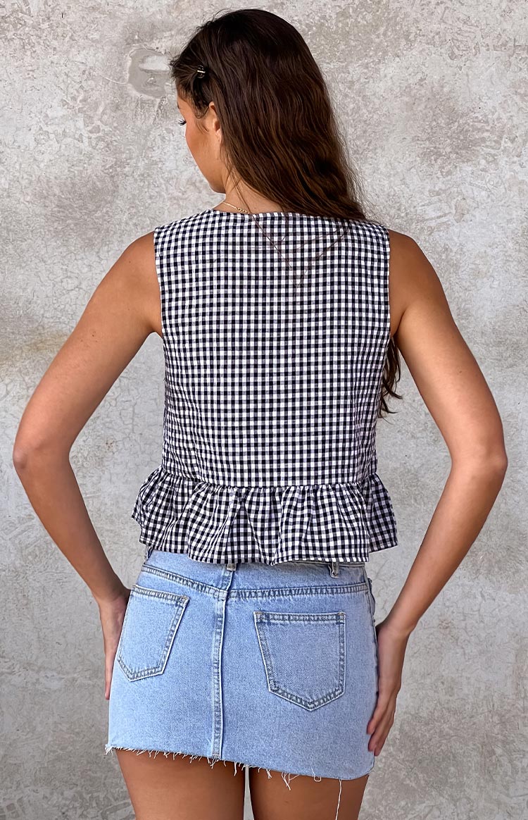 Rear view of a black and white gingham sleeveless top with a wide ruffled peplum hem