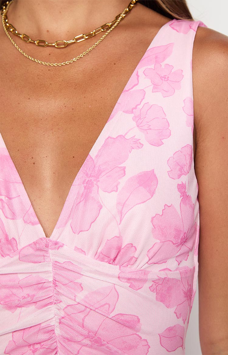 Close-up of the deep V-neckline and ruched bodice on a pink floral mesh maxi dress