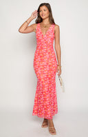 blonde model wearing a pink and orange floral print maxi dress with tan heels and a matching brown bag paired with gold jewellery